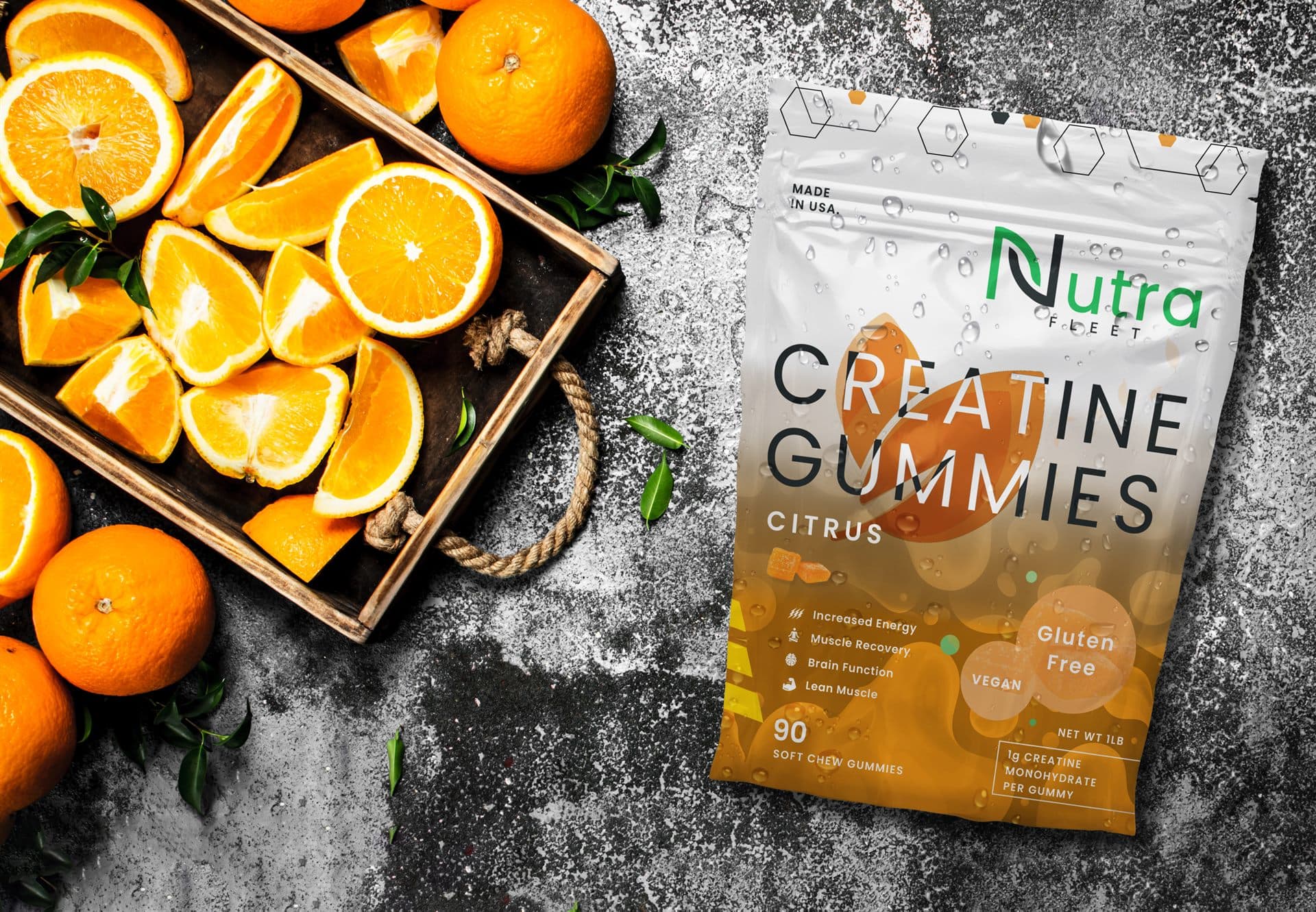 NutraFleet Creatine Gummies with fresh citrus on slate